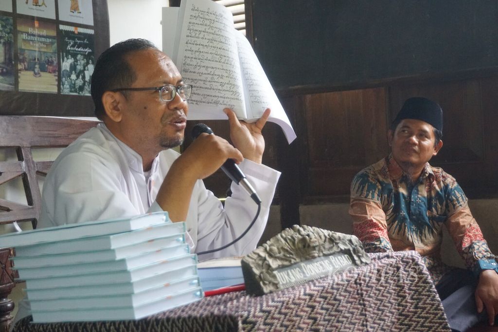 Nassirun Purwokartun menunjukkan naskah asli <i>Babad Pasir</i> berupa aksara Jawa dalam diskusi peluncuran buku <i>Babad Pasir</i> di Bale Pustaka, Desa Mandirancan, Kebasen, Banyumas, Jawa Tengah, Sabtu (7/10/2023).