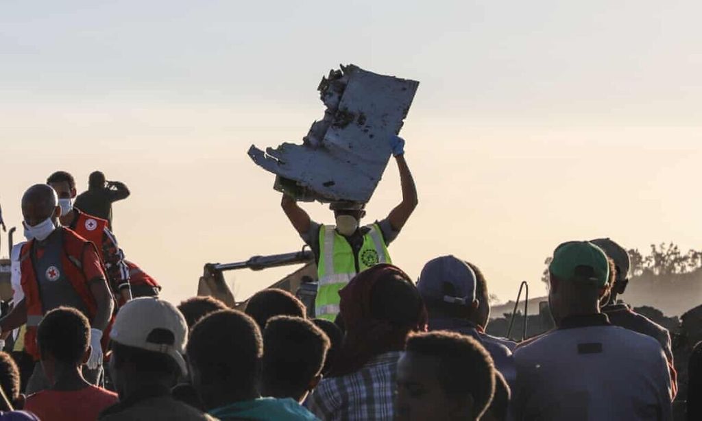 Seorang pria membawa sepotong puing pesawat Boeing 737 Max 8 milik Ethiopian Airlines yang jatuh di dekat kota Bishoftu, Ethiopia, Minggu (10/3/2019) waktu setempat.