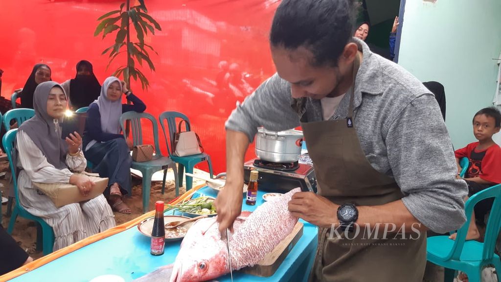 Chef La Ode Saiful Rahman mengolah ikan kakap merah di depan puluhan ibu-ibu peserta kegiatan Green Ramadhan, di Kelurahan Talia, Kendari, Sulawesi Tenggara, Sabtu (16/3/2024). Kegiatan yang diinisiasi oleh Perempuan Pesisir Sultra tersebut untuk mengingatkan pentingnya menjaga lingkungan sekaligus peran perempuan.