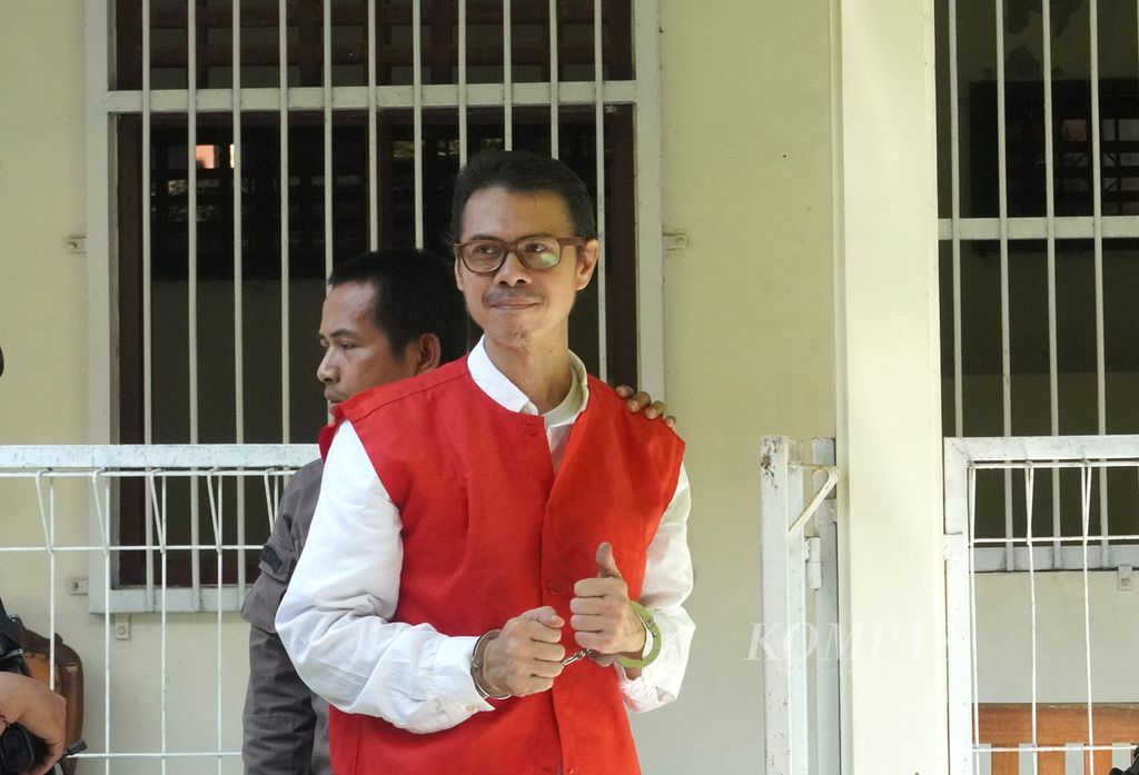 Daniel Frits Maurits Tangkilisan, aktivis lingkungan yang tengah terjerat kasus pelanggaran Undang-Undang ITE, bersiap memasuki ruang sidang di Pengadilan Negeri Jepara, Jawa Tengah, Kamis (4/4/2024).  