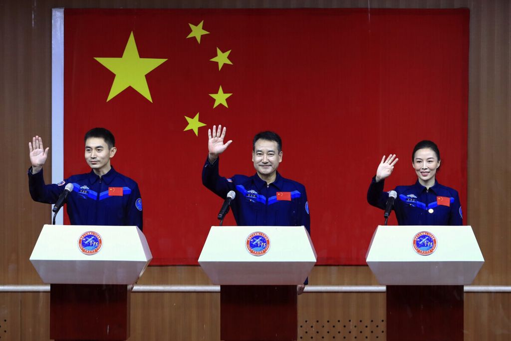 Foto yang dirilis kantor berita Xinhua memperlihatkan tiga astronot, yaitu Ye Guangfu, Zhai Zhigang dan Wang Yaping (dari kiri ke kanan), melambaikan tangan saat akan memberikan keterangan pada media di Pusat Peluncuran Satelit Jiuquan, Kamis (14/10), jelang peluncuran pesawat luar angkasa Shenzou-13. 