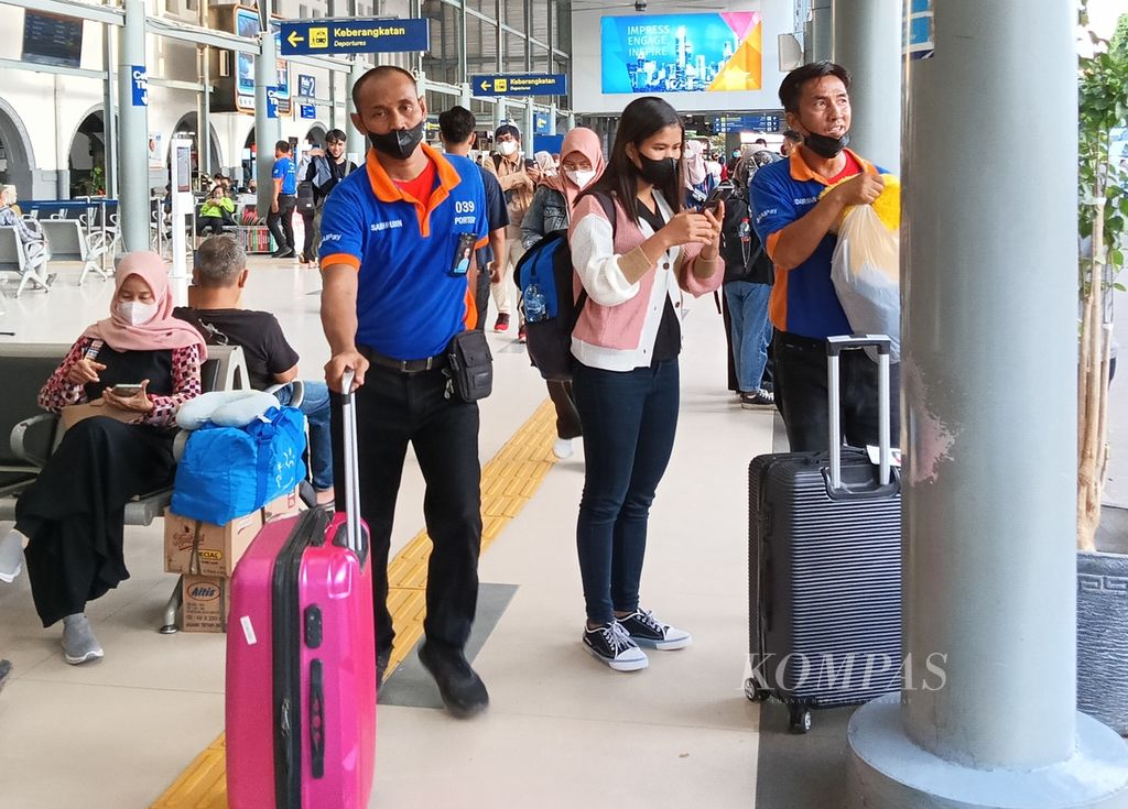 Seorang <i>porter</i> membawa barang penumpang yang baru saja tiba di Stasiun Pasar Senen, Jakarta, Kamis (9/3/2023), setelah melakukan perjalanan dari luar kota.