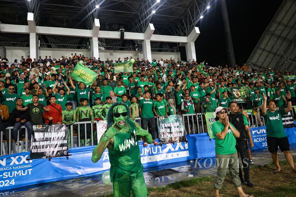 Suporter merayakan kemenangan Jawa Timur atas Jawa Barat pada final sepak bola PON Aceh-Sumut 2024 di Stadion Harapan Bangsa, Banda Aceh, Rabu (18/9/2024).