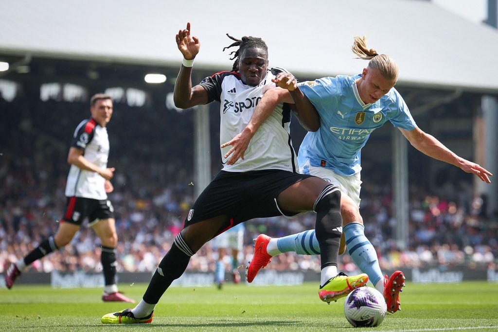 Pemain Fulham, Calvin Bassey (kiri), menjaga ketat penyerang Manchester City, Erling Haaland, dalam laga Liga Inggris antara Fulham dan Manchester City di Stadion Craven Cottage, London, Sabtu (11/5/2024). Manchester City memastikan gelar juara liga apabila menang atas Tottenham Hotspur, Rabu (15/5/2024) dini hari WIB, dan West Ham United, Minggu (19/5/2024).