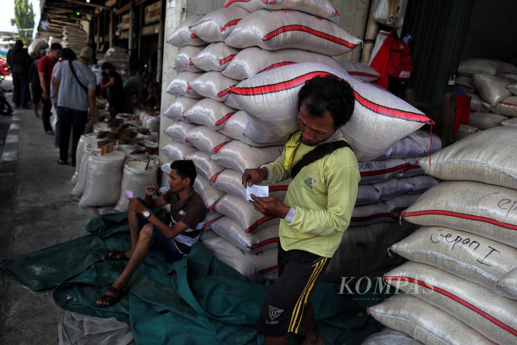 Buruh memanggul beras yang dibeli oleh pelanggan di Pasar Induk Beras Cipinang, Jakarta Timur, Minggu (30/5/2021). Pemerintah saat ini tengah menggodok berdirinya Badan Pangan Nasional. Badan baru ini akan bertanggung jawab mengendalikan harga dan memenuhi kebutuhan sembilan bahan pangan pokok, termasuk beras di dalam negeri.