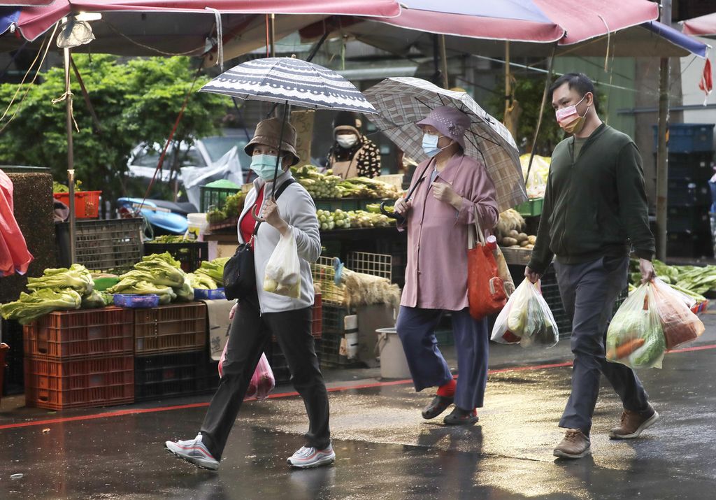 Warga Taiwan yang taat protokol kesehatan berbelanja di sebuah pasar tradisional di Taipei, Taiwan pada Sabtu (22/1/2022).