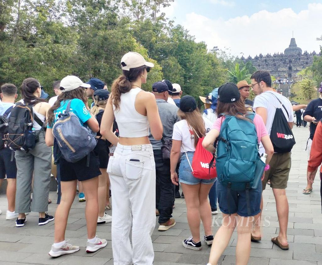 Rombongan wisatawan asal Italia tampak berkelompok sebelum melanjutkan perjalanan mereka menyusuri bangunan Candi Borobudur, Minggu (6/8/2023).