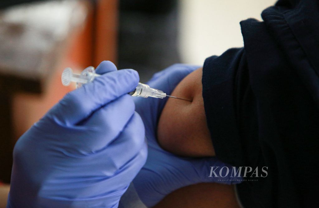 Warga menerima suntikan vaksin Covid-19 dosis ketiga atau penguat di RPTRA Gondangdia, Jakarta Pusat, Senin (28/3/2022).