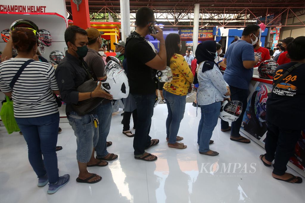 Pengunjung mengantre membeli helm di salah satu stan Jakarta Fair Kemayoran 2022, Sabtu (11/6/2022). Setelah dua tahun ditiadakan karena pandemi Covid-19, ajang pameran dan pertunjukan Jakarta Fair kembali digelar pada 9 Juni hingga 17 Juli 2022 dan menyedot animo pengunjung. 