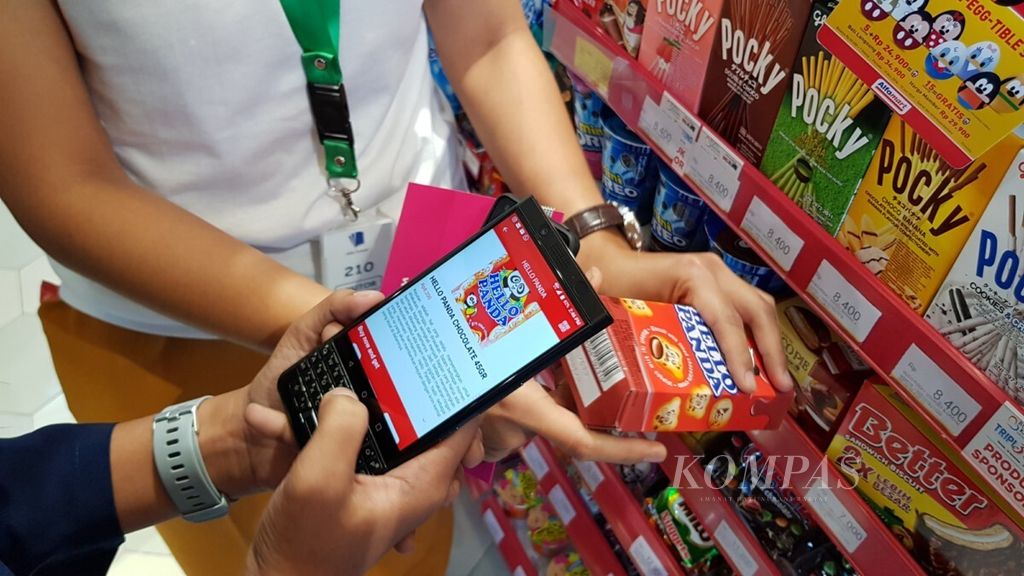Pengguna mengoperasikan aplikasi Allwiz untuk memindai kode produk barang belanjaan di minimarket Alfamart untuk dimasukkan ke dalam keranjang sambil mengumpulkan poin, Selasa (11/12/2018). 