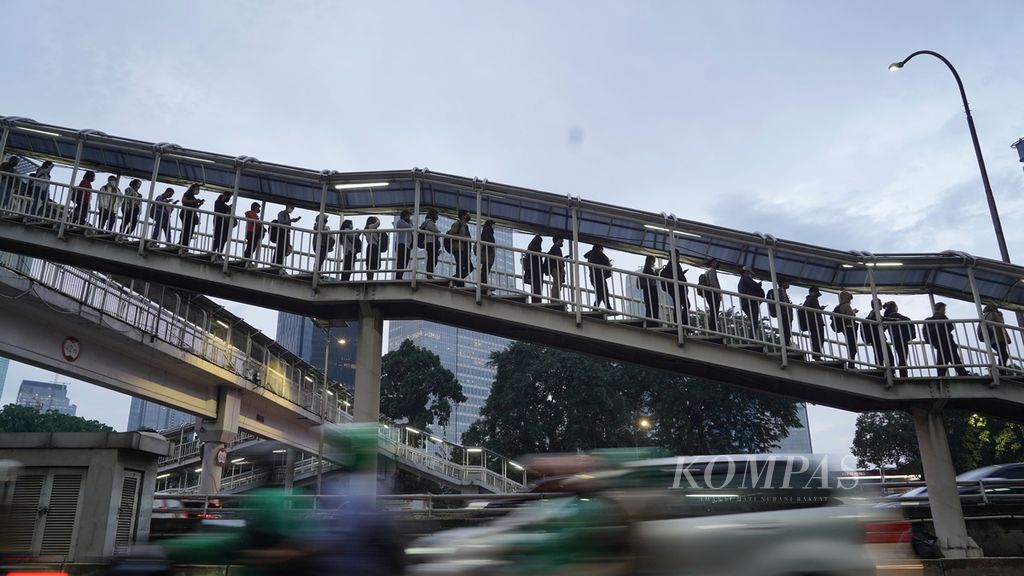 Penumpang antre memasuki halte bus Transjakarta di Jalan Gatot Subroto, Jakarta Selatan, Senin (12/12/2022). 