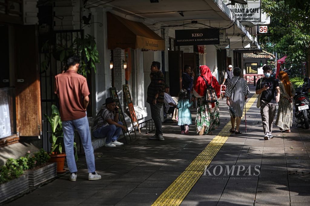 Warga berjalan di atas trotoar di kawasan Cikini, Jakarta, Jumat (1/3/2024). Fasilitas trotoar yang memadai turut mendorong minat warga untuk berjalan kaki dan menggunakan transportasi umum. 