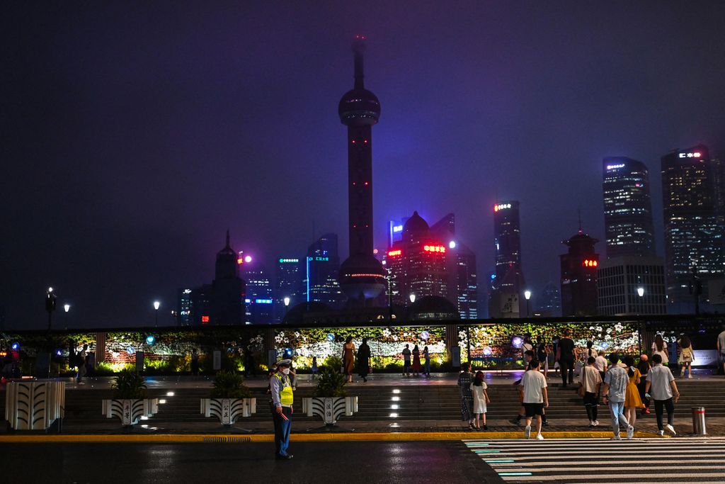 Orang-orang melintasi jalan di kawasan Bund, di tepi Sungai Huangpu, Shanghai, China, 23 Agustus 2022. Pada 2014, China untuk pertama kali menggusur besaran produksi domestik bruto Amerika Serikat. 