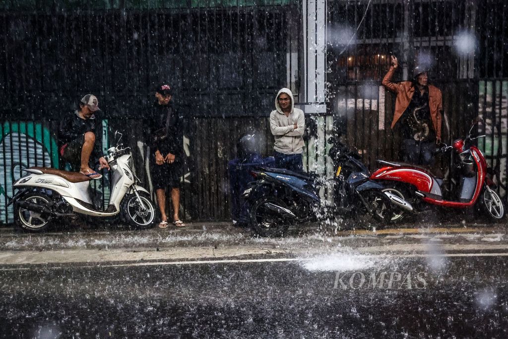 Pengendara motor berteduh saat hujan deras mengguyur kawasan Pondok Benda, Tangerang Selatan, Banten, Rabu (1/5/2024). Badan Meteorologi, Klimatologi, dan Geofisika menyatakan fenomena El Nino berpotensi digantikan oleh La Nina.