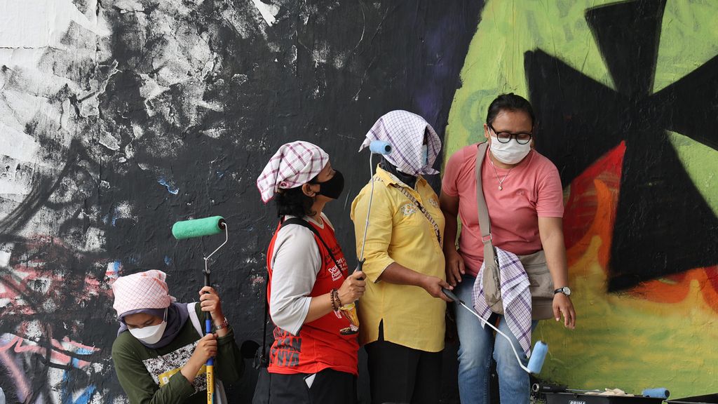 Pekerja rumah tangga bersiap mengecat tembok penyangga jembatan yang akan dilukis mural di Jembatan Kewek di Kotabaru, Yogyakarta, Rabu (15/12/2021). Mereka menggelar aksi untuk memprotes pembahasan RUU Perlindungan Pekerja Rumah Tangga yang masih terkatung-katung selama belasan tahun. Aksi itu juga sebagai wujud protes terhadap masih sering terjadinya tindakan kekerasan yang dilakukan oleh majikan terhadap pekerja rumah tangga. Mereka juga menuntut pemenuhan sejumlah hak mereka melalui aksi itu.