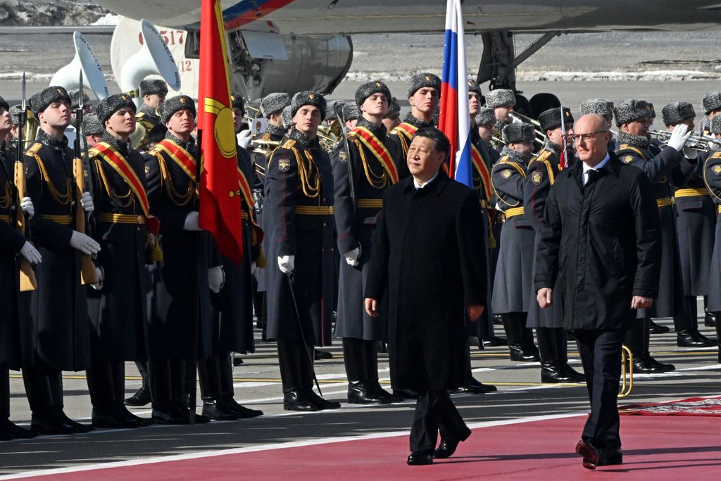 Presiden China Xi Jinping, didampingi Wakil Perdana Menteri Rusia Dmitry Chernyshenko, berjalan melewati pasukan kehormatan Rusia saat upacara penyambutan di bandara Vnukovo Moskwa, Rusia, Senin (20/3/2023).  