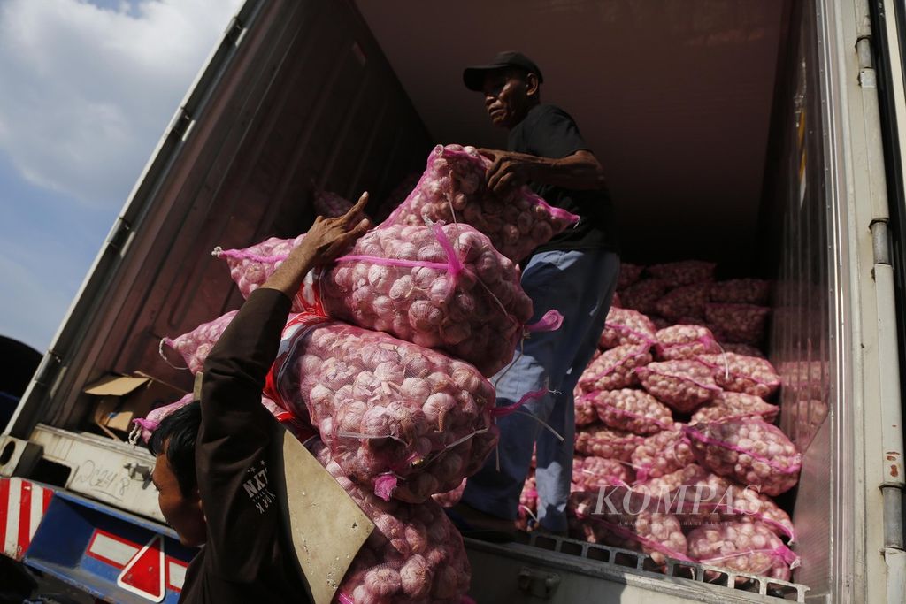 Buruh membongkar bawang putih impor yang baru tiba di Pasar Induk Kramatjati, Jakarta Timur, Minggu (9/7/2023). Berdasarkan laman bi.go.id/hargapangan, harga rata-rata nasional bawang putih saat ini mencapai Rp 42.000 per kilogram.
