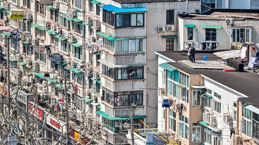 Warga berdiri di atas atap gedung selama tahap kedua karantina total wilayah akibat penularan Covid-19 di Distrik Jingan, 3 April 2022. 