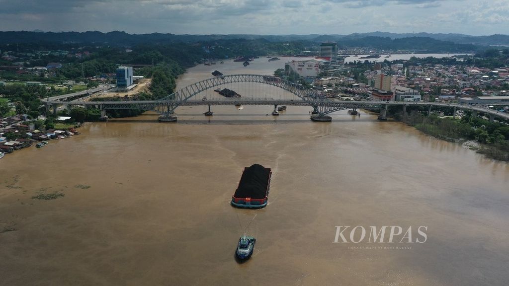 Kapal tongkang yang mengangkut batubara melintas di Sungai Mahakam, di Kota Samarinda, Kalimantan Timur, Senin (25/12/2023).