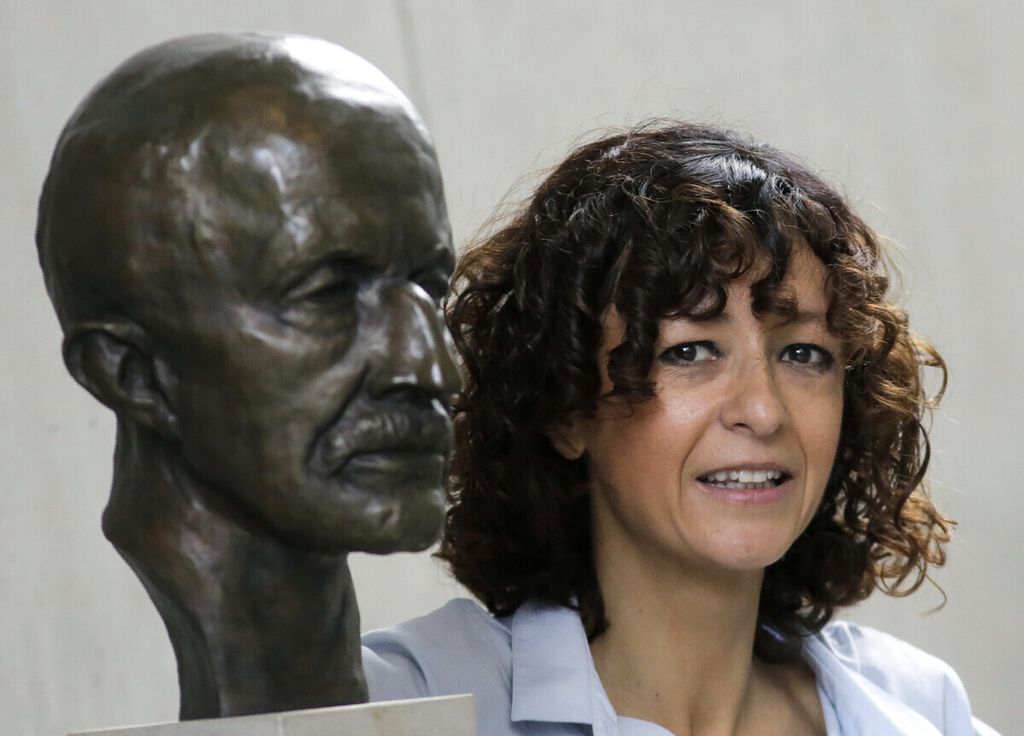 French microbiologist Emmanuelle Charpentier poses near a statue of Max Planck in Berlin, Germany, Wednesday, Oct. 7, 2020. French scientist Emmanuelle Charpentier and American Jennifer A. Doudna have won the Nobel Prize 2020 in chemistry for developing a method of genome editing likened to ‘molecular scissors’ that offer the promise of one day curing genetic diseases. 