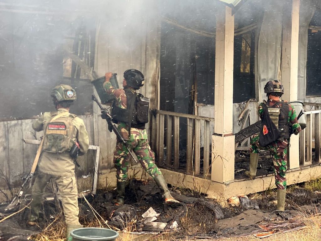 Anggota TNI dari Satgas Pamtas Mobile Yonif Raider 300/BJW dan Satgas Elang memadamkan api yang membakar bangunan rumah tenaga kesehatan di Distrik Ilaga, Kabupaten Puncak, Papua Tengah, Senin (11/9/2023). Total sebanyak 10 rumah diduga dibakar kelompok kriminal bersenjata.