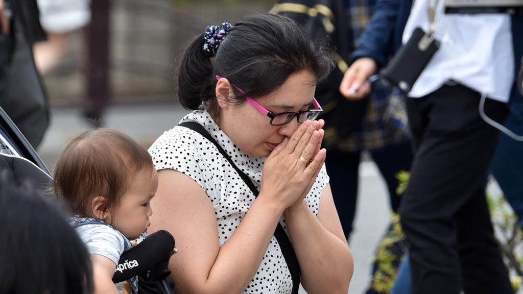 Pelayat membawa bayi ke lokasi untuk mengenang korban penyerangan di Kawasaki, Jepang, Mei 2019.
