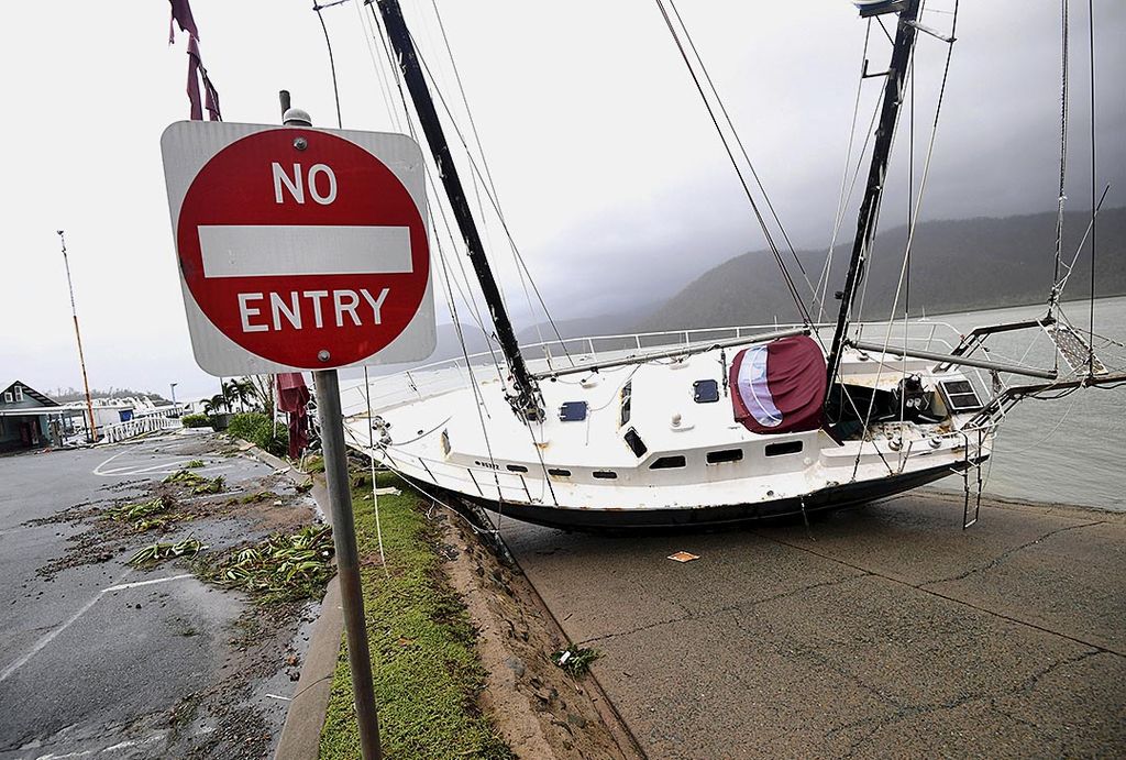 Sebuah perahu  terlempar ke dermaga di Pelabuhan Shute, Airlie Beach, Rabu (29/3), setelah dihantam badai Debbie, sehari sebelumnya. Badai kategori 4 itu melanda wilayah pantai timur laut Queensland, Australia, menyebabkan kerusakan luas.