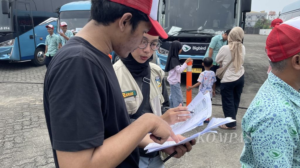 Sejumlah panitia mengecek daftar peserta dan posisi duduk di dalam bus menjelang pelepasan armada program Isuzu Mudik Gratis #DitemaniYangSejalan di Bekasi, Jawa Barat, Jumat (5/4/2024).