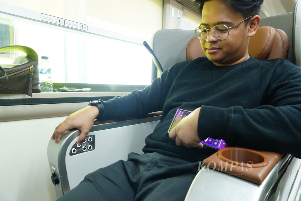 Seorang penumpang mengatur sandaran kursinya dengan tombol-tombol elektronik di gerbong Luxury Kereta Api Argo Dwipangga yang singgah di Stasiun Gambir, Jakarta Pusat, Rabu (27/12/2023). Sejak 13 Desember 2023, Argo Dwipangga menggunakan kereta New Generation buatan PT INKA, baik di kelas Luxury maupun Eksekutif.