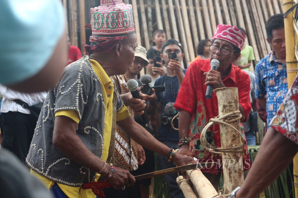 Figures from Benakitan Village, in a traditional event, wanted to cut wood across as a sign of their good intentions to come to Kinipan, Lamandau Regency, Central Kalimantan, on Tuesday (6/12/2022).