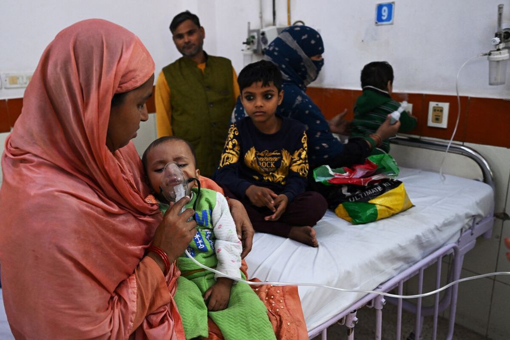 Seorang ibu membantu anaknya bernapas dengan bantuan nebulizer di bangsal darurat rumah sakit anak Chacha Nehru Bal Chikitsalaya di New Delhi, India, Selasa (7/11/2023). 