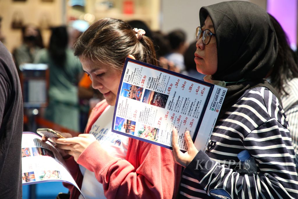 Visitors queue up at one of the travel agency booths participating in a travel exhibition in Gandari City mall, South Jakarta, on Friday (25/8/2023). Various offers such as cheap airfare for the 2024 school holiday season are among the visitors' targets.