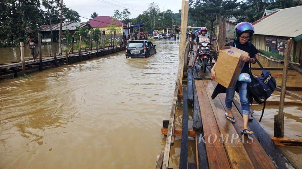 Warga menyeberang dengan rakit sederhana di Desa Sampara, Kecamatan Sampara, Kabupaten Konawe, Jumat (14/6/2019). Banjir merendam empat kabupaten di wilayah Sulawesi Tenggara saat itu. 