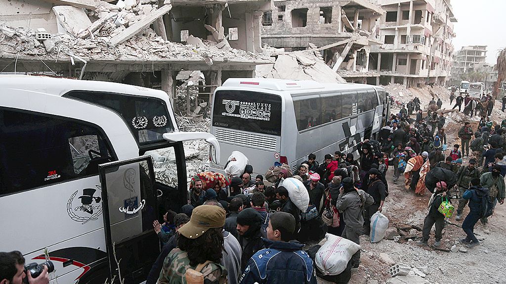 Warga Ghouta mengantre untuk naik bus yang akan membawa mereka keluar dari Arbin, Sabtu (24/3) 