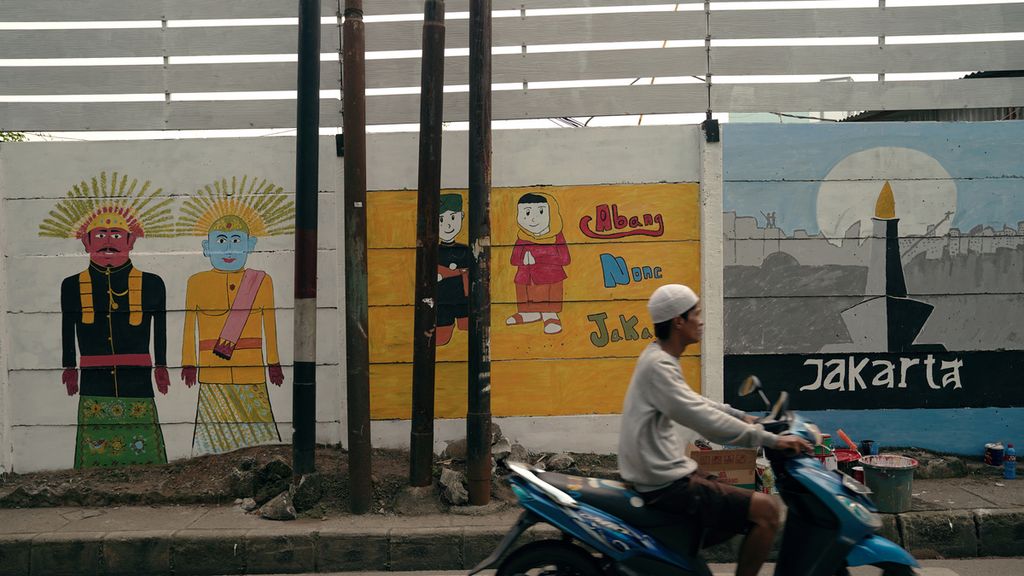 Warga melewati mural yang meramaikan HUT Ke-495 DKI Jakarta di Cipinang Besar Selatan, Jatinegara, Jakarta Timur, Minggu (19/6/2022). Pemerintah Provinsi DKI Jakarta menyambut hari jadi ke-495 dengan menggelar sejumlah acara sebulan penuh mulai 24 Mei sampai 25 Juni 2022. 