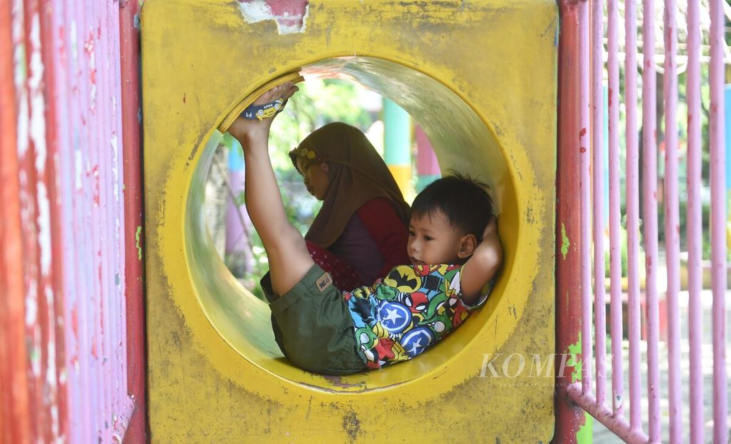 Anak bersantai di Taman Prestasi saat libur Hari Buruh, di Surabaya, Rabu (1/5/2024). Saat libur Hari Buruh, banyak warga liburan murah dengan berkunjung ke taman. Di taman tersebut pengunjung dapat menikmati sejumlah wahana permainan juga menikmati pepohonan rindang. 