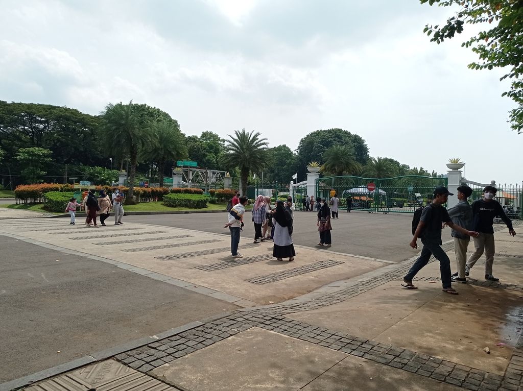 Wisatawan berswafoto dan piknik di muka pintu masuk Monumen Nasional, Jakarta, yang masih tutup untuk umum karena pandemi Covid-19, Rabu (4/5/2022).