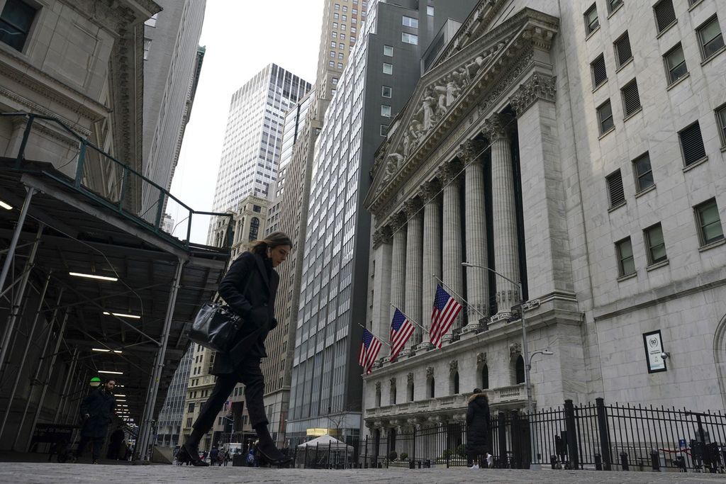 Pejalan kaki melewati gedung Bursa Efek New York, 24 Februari 2022. 