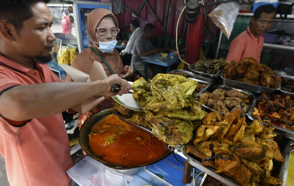 Pelanggan memesan gulai kepala ikan di kedai nasi kapau Uni Upik di Jalan Kramat Raya, Senen, Jakarta Pusat, Jumat (2/12/2022). 