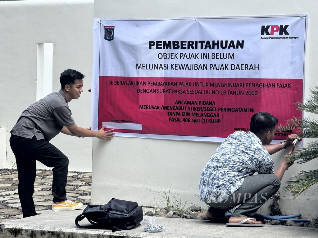 Petugas memasang spanduk berisi pemberitahuan tunggakan pajak di Royal Avila Boutique Resort yang berada di Kecamatan Pemenang, Kabupaten Lombok Utara, Nusa Tenggara Barat, Sabtu (16/3/2024). 