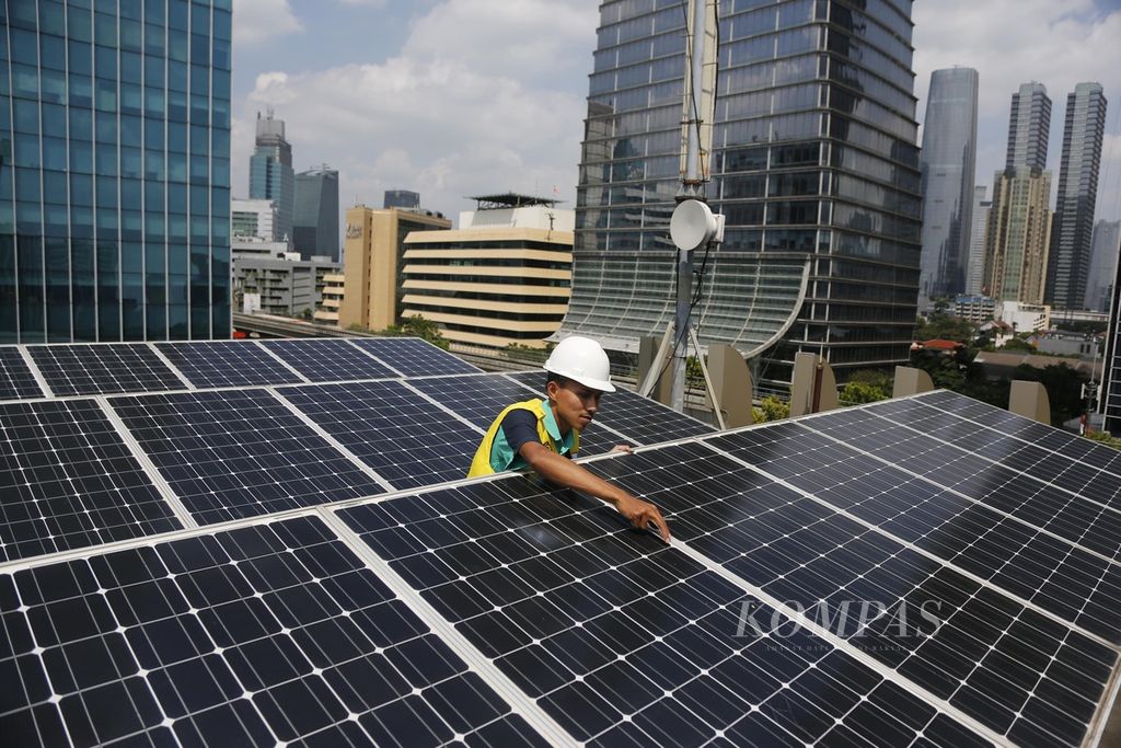 Teknisi merawat panel surya yang terpasang di atap gedung Direktorat Jenderal Ketenagalistrikan Kementerian ESDM, Jakarta, Jumat (5/5/2023).