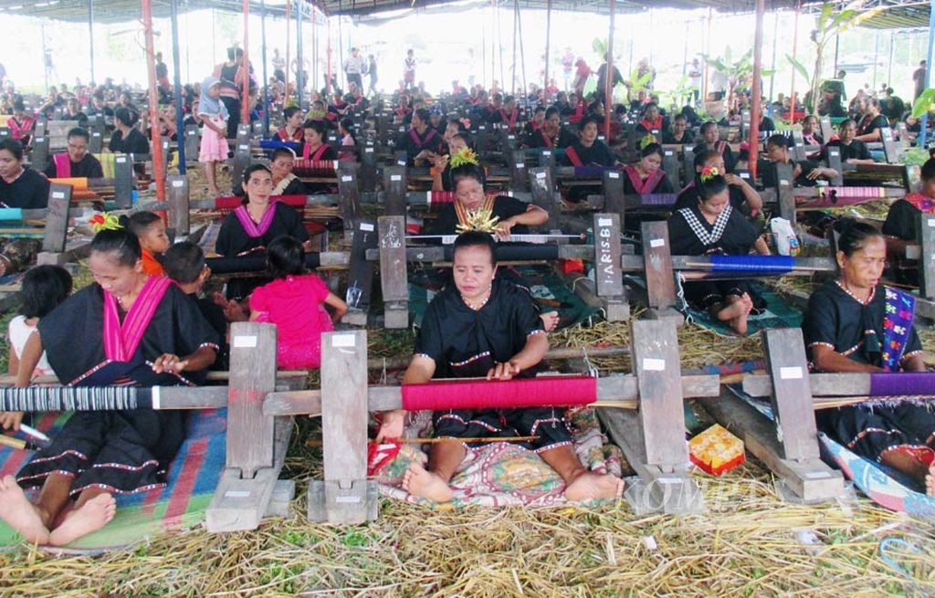 Sekitar 1.500 perajin bersama-sama menenun kain songket dalam Festival Begawe Jelo Nyesek di Desa Sukarara, Lombok Tengah, Nusa Tenggara Barat, Rabu (26/7). Produk kain songket buatan tangan yang rata-rata dikerjakan dalam waktu seminggu itu menjadi cendera mata bagi wisatawan yang berkunjung ke Pulau Lombok.