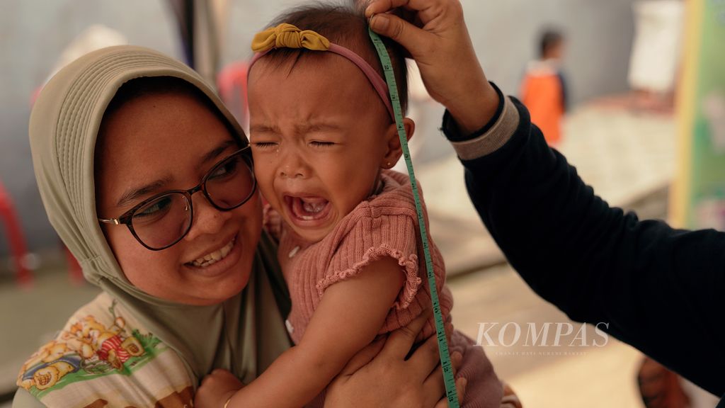 Anak balita menangis saat diukur tinggi badannya dalam Bulan Imunisasi Anak Nasional (BIAN) dan pneumokokus konjugasi (PCV) di Posyandu Kuntum Mekar, Klender, Jakarta Timur, akhir September 2022. 