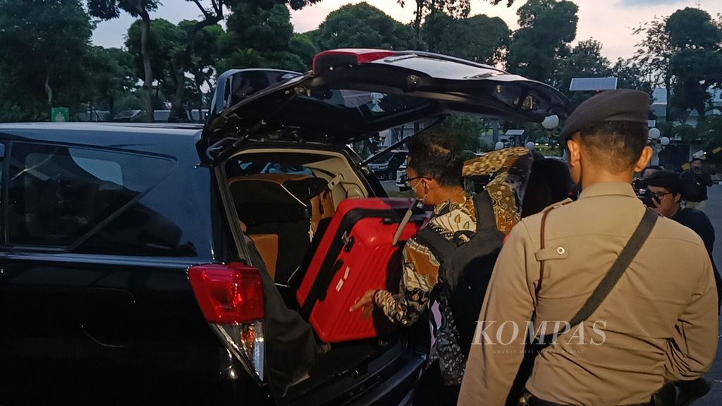 Penyidik Komisi Pemberantasan Korupsi memasukkan barang bukti berupa koper berwarna merah seusai menggeledah Gedung Sekretariat Jenderal DPR, Kompleks Parlemen, Jakarta, Selasa (30/4/2024) sore. 