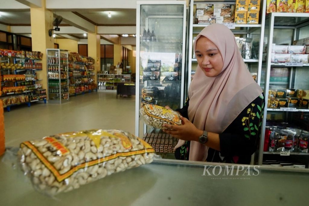 Mersi (27), pengunjung di toko oleh-oleh Mubaraq, memilih mete untuk kerabatnya di Kendari, Sulawesi Tenggara, Minggu (23/7/2023). Mete dan berbagai bentuk olahannya menjadi pilihan utama masyarakat saat berkunjung ke wilayah ini.