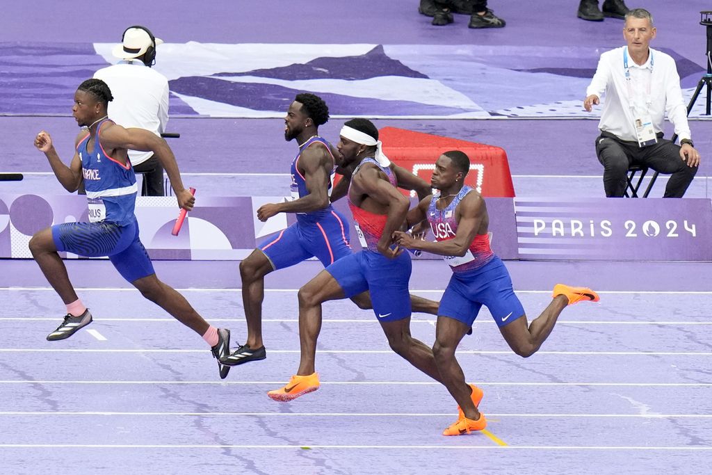 Sprinter Amerika Serikat, Christian Coleman (kanan), kesulitan menyerahkan tongkat kepada rekannya, Kenneth Bednarek, pada final nomor 4 x 100 meter estafet Olimpiade Paris 2024 di Saint-Denis, 9 Agustus 2024. Tim AS didiskualifikasi, sedangkan Kanada memenangi nomor ini.