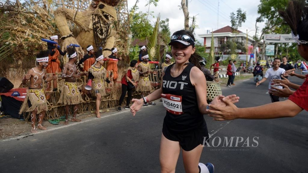Sejumlah siswa dari Papua menghibur pelari Borobudur Marathon 2019 powered by Bank Jateng yang melintas di Desa Wringinputih, Kecamatan Borobudur, Magelang, Jawa Tengah, Minggu (17/11/2019). 