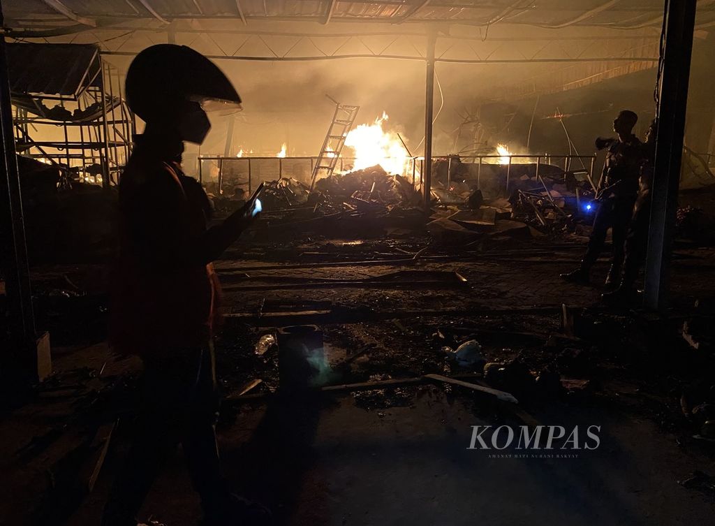 Warga melihat kebakaran di relokasi Pasar Johar di kawasan Masjid Agung Jawa Tengah, Kecamatan Gayamsari, Kota Semarang, Rabu (2/2/2022). Penyebab kebakaran masih diselidiki. 