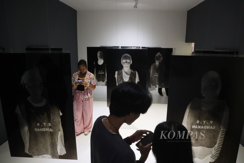 Rangkaian foto karya fotografer Romi Perbawa berjudul "Au Loim Fain" yang berkisah tentang buruh migran ditampilkan dalam Artjog 2023 di Jogja National Museum, Yogyakarta, Selasa (4/7/2023). 