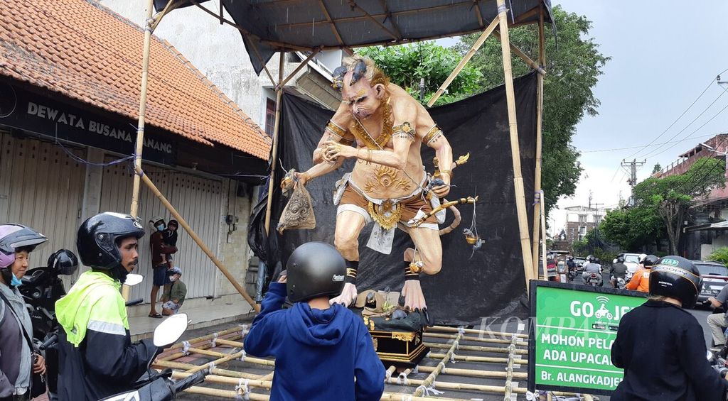 Warga mengamati patung ogoh-ogoh yang diletakkan di tepi jalan di Kota Denpasar, Bali, Rabu (2/3/2022). Menjelang hari raya Nyepi Tahun Saka 1944 pada Kamis (3/3/2022), warga mengadakan Ngerupuk, yakni ritual membersihkan dan menyucikan alam dari unsur negatif agar harmoni, yang disemarakkan dengan mengarak patung ogoh-ogoh. 